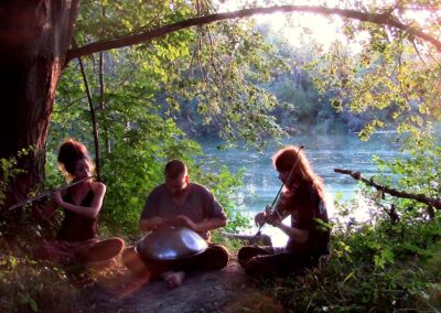 Abendstimmung: Musikgruppe sitzt am See und macht Musik