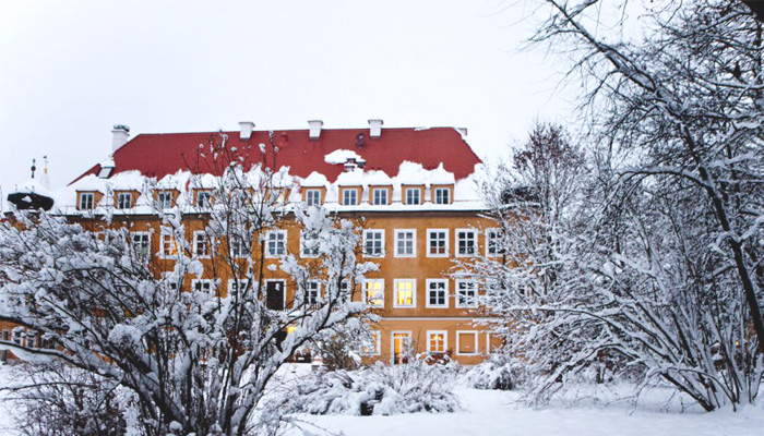 Blick auf das tief verschneite Schlosshotel Blumenthal in der Abenddämmerung
